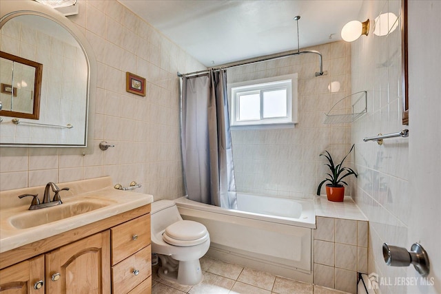 full bath with tile walls, tile patterned floors, shower / bathtub combination with curtain, toilet, and vanity