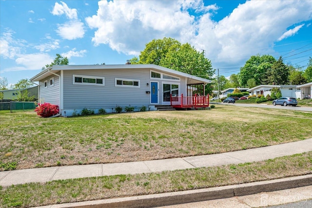 view of front of home featuring a front yard and a deck