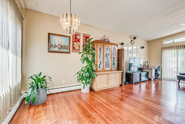 dining space featuring plenty of natural light, a baseboard heating unit, and light wood-type flooring