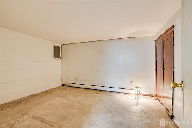 spare room with unfinished concrete floors and a baseboard heating unit
