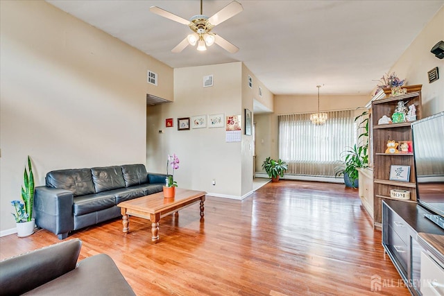 living room with a chandelier, a ceiling fan, wood finished floors, and baseboards