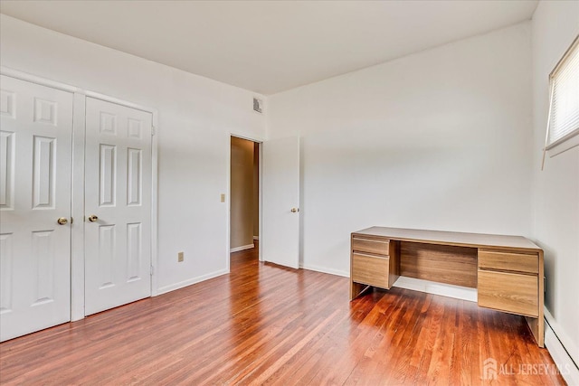 unfurnished bedroom featuring wood finished floors and baseboards