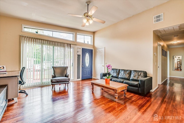 living area featuring wood finished floors, ceiling fan, an office area, and baseboards