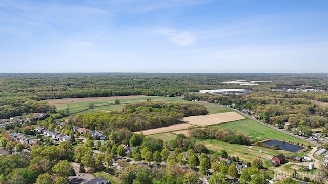 drone / aerial view of a nearby body of water and a forest