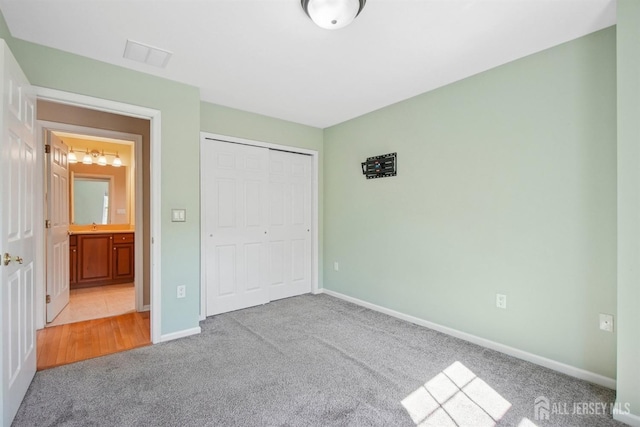 unfurnished bedroom with carpet, baseboards, and a closet