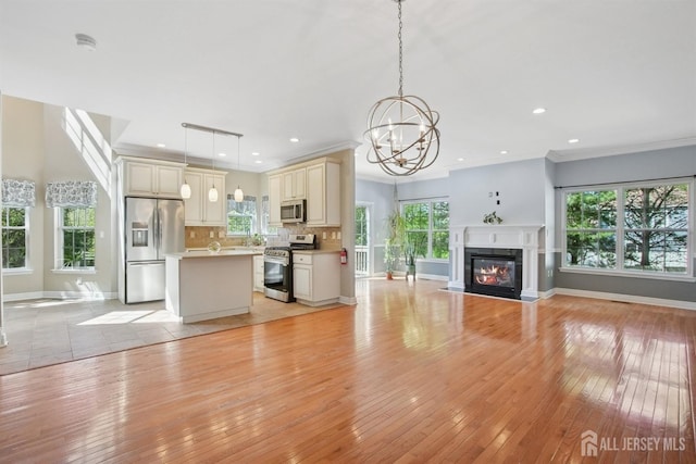 unfurnished living room featuring light wood-type flooring, a chandelier, baseboards, a glass covered fireplace, and recessed lighting