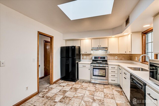 221 S Pine Ave S, South Amboy, NJ 08879 - kitchen with black appliances, under cabinet range hood, backsplash, light countertops, and light stone finish flooring