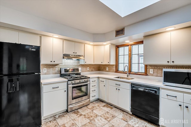 221 S Pine Ave S, South Amboy, NJ 08879 - kitchen with black appliances, under cabinet range hood, light countertops, and tasteful backsplash