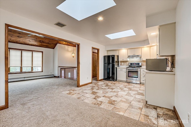 221 S Pine Ave S, South Amboy, NJ 08879 - kitchen with a skylight, gas stove, a baseboard radiator, freestanding refrigerator, and under cabinet range hood