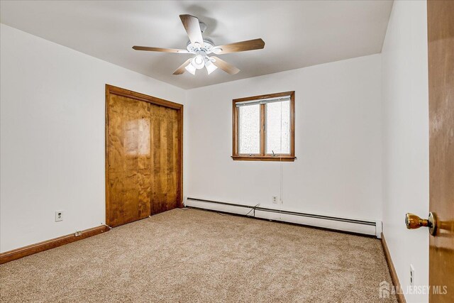 221 S Pine Ave S, South Amboy, NJ 08879 - unfurnished bedroom featuring a baseboard heating unit, carpet flooring, a closet, and ceiling fan