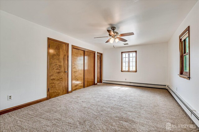 221 S Pine Ave S, South Amboy, NJ 08879 - unfurnished bedroom featuring a baseboard heating unit, multiple closets, carpet, and a ceiling fan