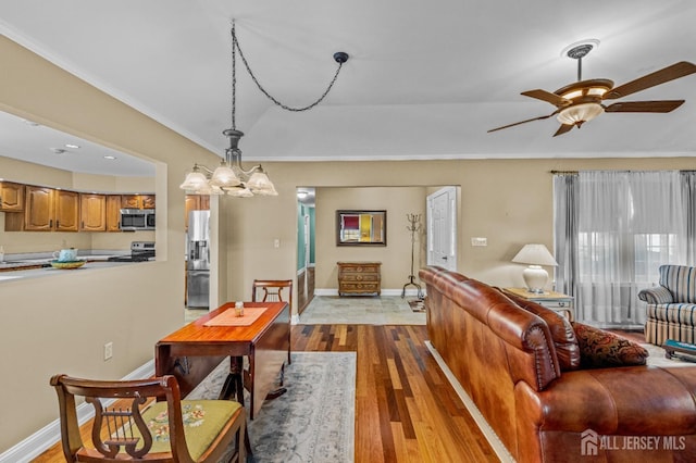 dining space featuring light wood-type flooring, a ceiling fan, and baseboards