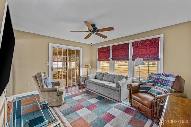 living area featuring ceiling fan and baseboards