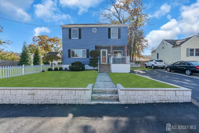 front facade with a front yard and covered porch