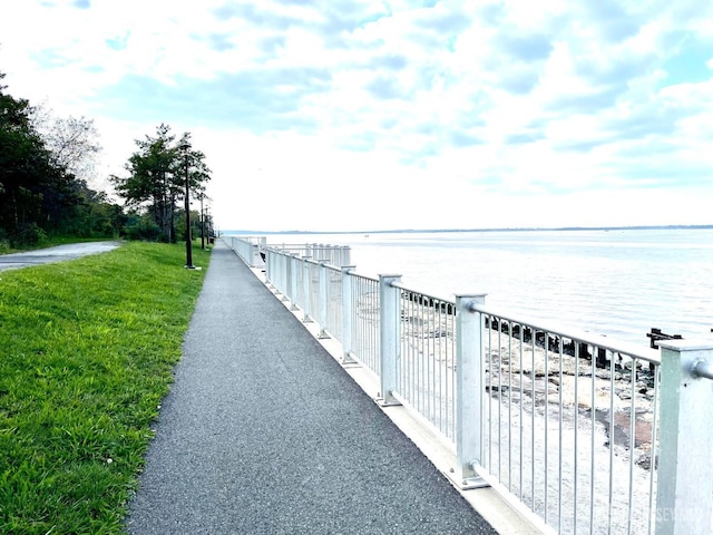 surrounding community featuring a water view and a lawn