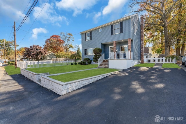 view of front of home featuring fence and a front lawn