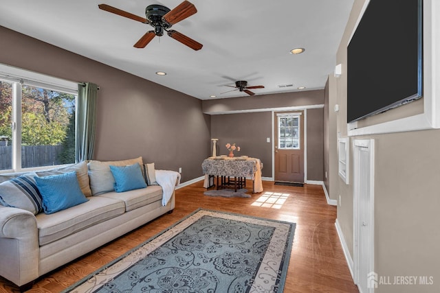 living room featuring recessed lighting, wood finished floors, visible vents, and baseboards