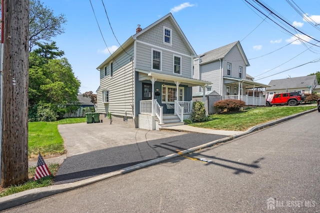 39 Embroidery St, Sayreville, NJ 08879 - view of front facade with a porch, a chimney, driveway, and a front yard