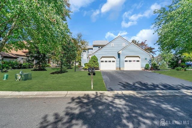 view of front of house with aphalt driveway, a garage, and a front lawn