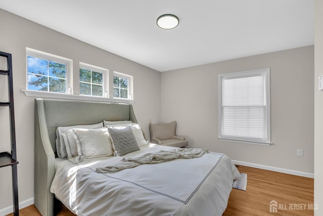 bedroom featuring baseboards and wood finished floors