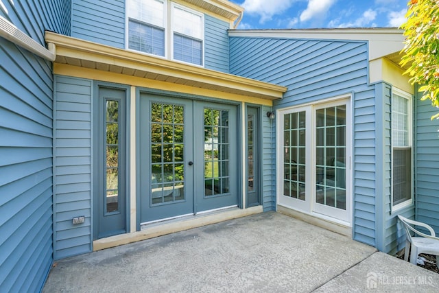 property entrance featuring a patio area and french doors