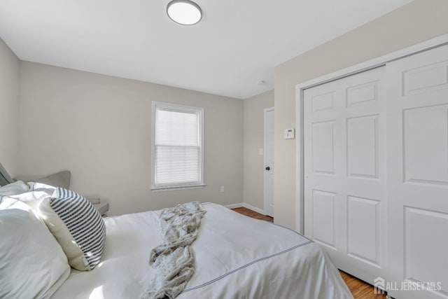 bedroom featuring wood finished floors, a closet, and baseboards