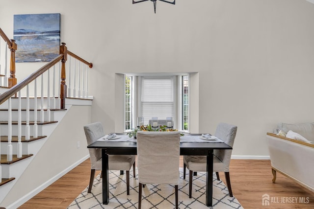 dining room with baseboards, wood finished floors, and stairs