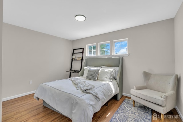 bedroom with baseboards and wood finished floors