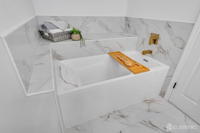 full bath featuring marble finish floor and a tub