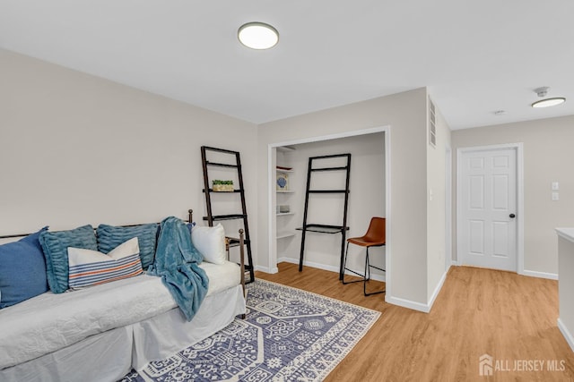 living area with light wood-type flooring and baseboards