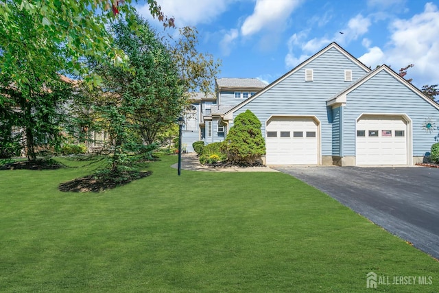 view of front of home featuring a garage, a front yard, and driveway