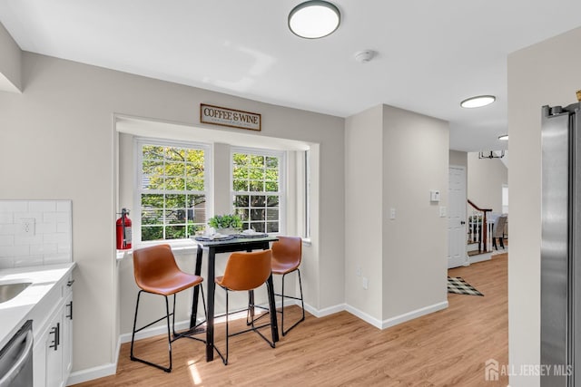 dining room with baseboards and light wood-type flooring