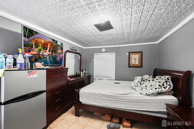 tiled bedroom featuring crown molding and stainless steel refrigerator