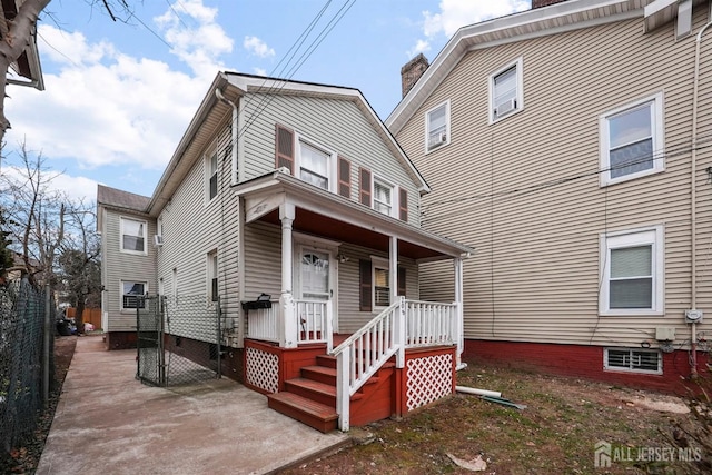 view of front of home featuring covered porch and fence