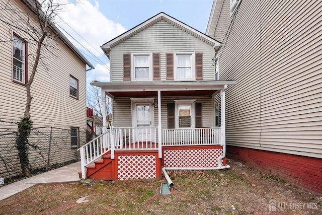 traditional-style house with a porch and fence