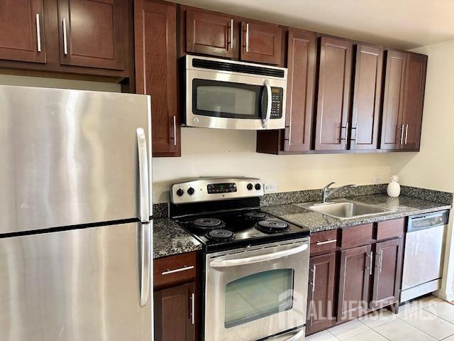 110 Somerset St Unit 2101, New Brunswick, NJ 08901 - kitchen featuring appliances with stainless steel finishes, dark stone counters, and light tile patterned flooring