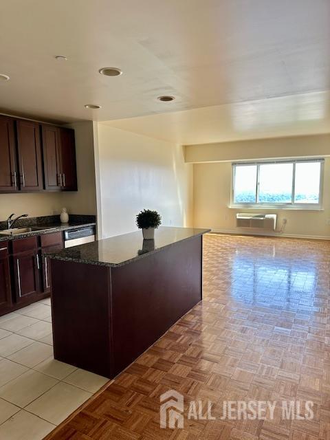 110 Somerset St Unit 2101, New Brunswick, NJ 08901 - kitchen with dark stone countertops, dark brown cabinetry, a center island, an AC wall unit, and dishwasher