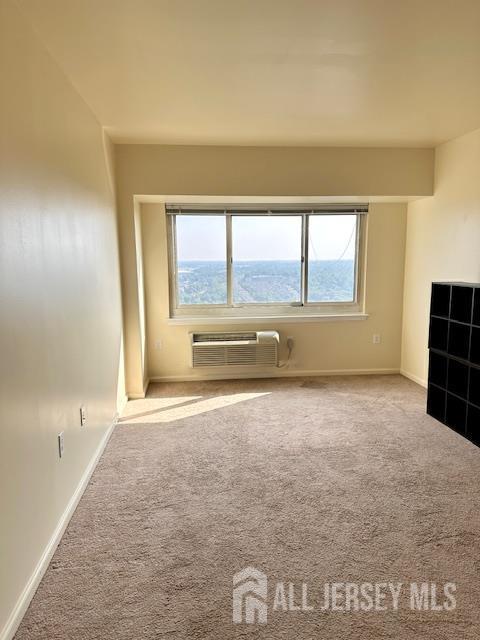 110 Somerset St Unit 2101, New Brunswick, NJ 08901 - unfurnished living room featuring a wall unit AC and carpet flooring