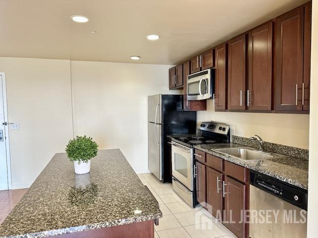 110 Somerset St Unit 2101, New Brunswick, NJ 08901 - kitchen featuring stainless steel appliances, a center island, dark stone counters, light tile patterned floors, and recessed lighting