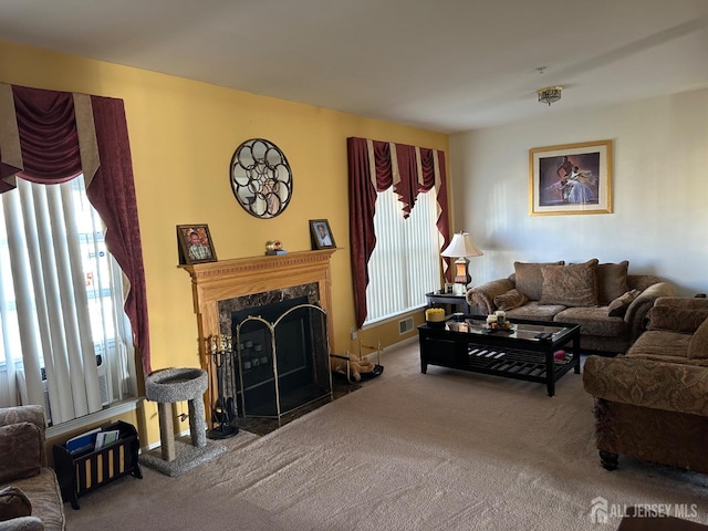 living area with visible vents, carpet, a healthy amount of sunlight, and a fireplace