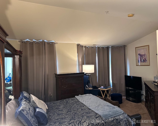 carpeted bedroom with lofted ceiling