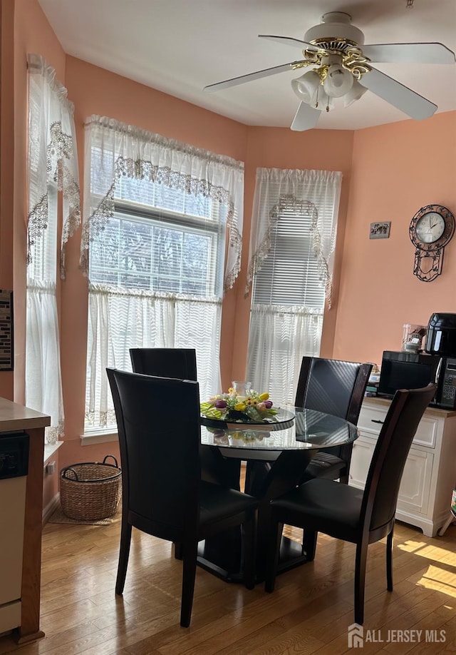 dining room with light wood-type flooring and a ceiling fan