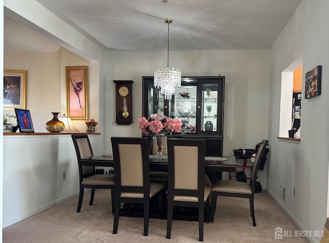 carpeted dining space featuring an inviting chandelier, visible vents, and baseboards