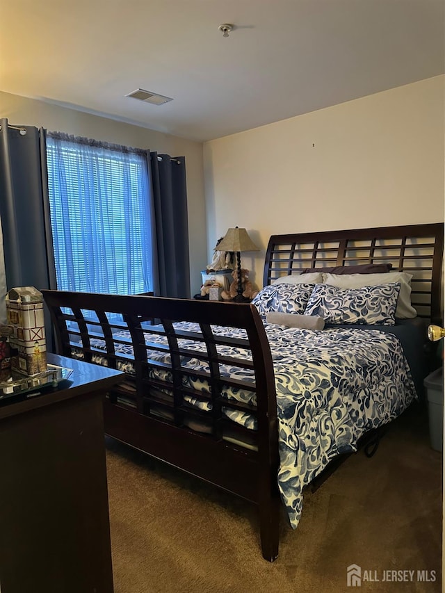 carpeted bedroom featuring visible vents