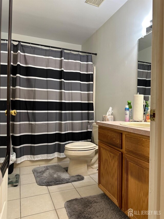 full bathroom featuring vanity, visible vents, curtained shower, tile patterned floors, and toilet