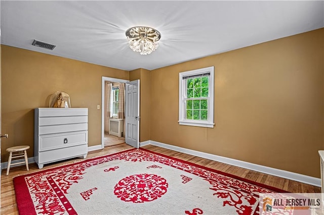 57 Patton Dr, East Brunswick, NJ 08816 - bedroom featuring baseboards, wood finished floors, and a chandelier