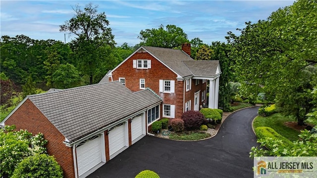 57 Patton Dr, East Brunswick, NJ 08816 - view of front of property with a chimney, driveway, brick siding, and a garage