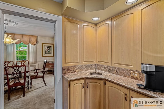 57 Patton Dr, East Brunswick, NJ 08816 - kitchen with light carpet, wallpapered walls, light brown cabinetry, a sink, and light stone counters