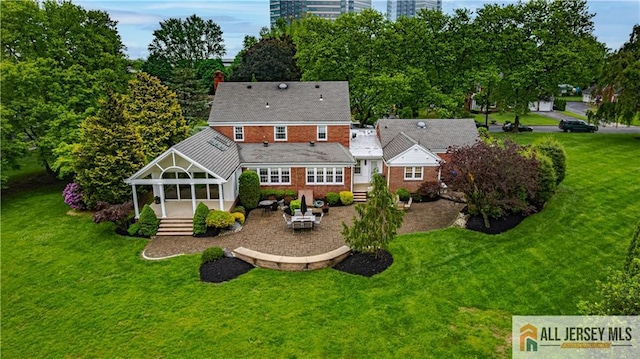 57 Patton Dr, East Brunswick, NJ 08816 - rear view of property with a yard, a patio area, a chimney, and view of scattered trees