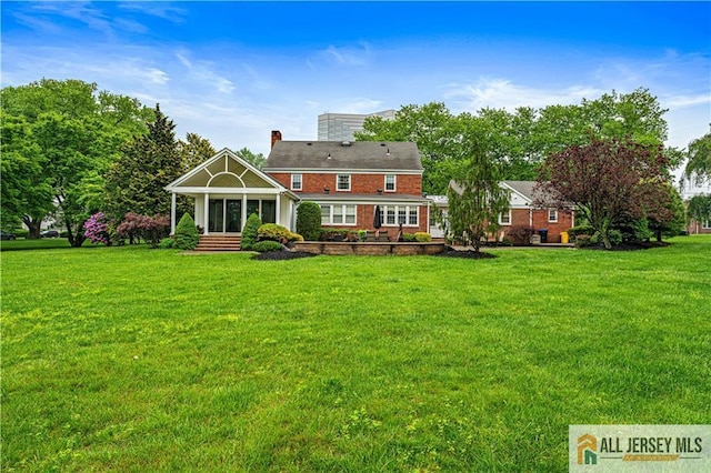 57 Patton Dr, East Brunswick, NJ 08816 - back of house featuring a lawn, brick siding, and a sunroom